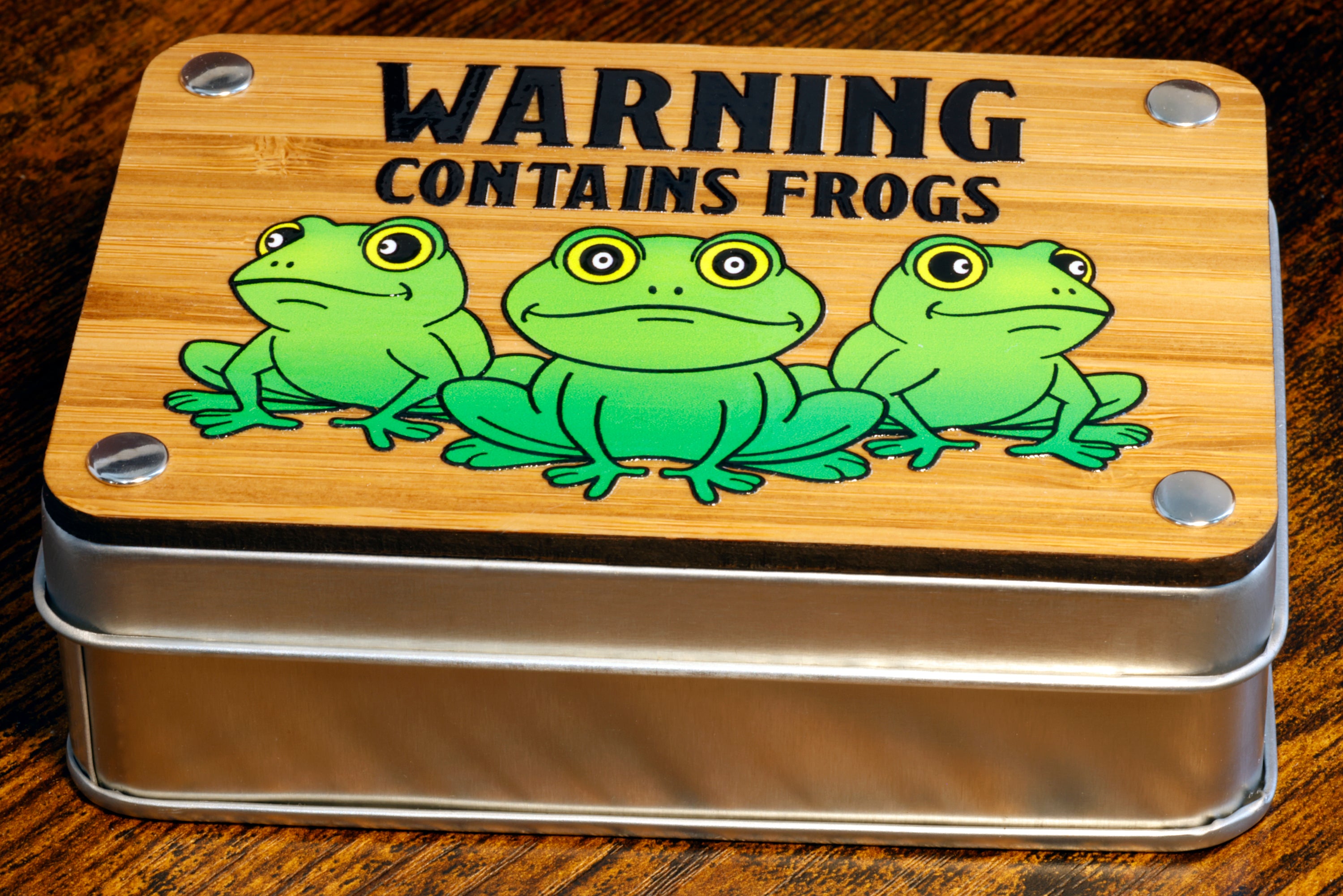 a tin with a picture of three frogs on it